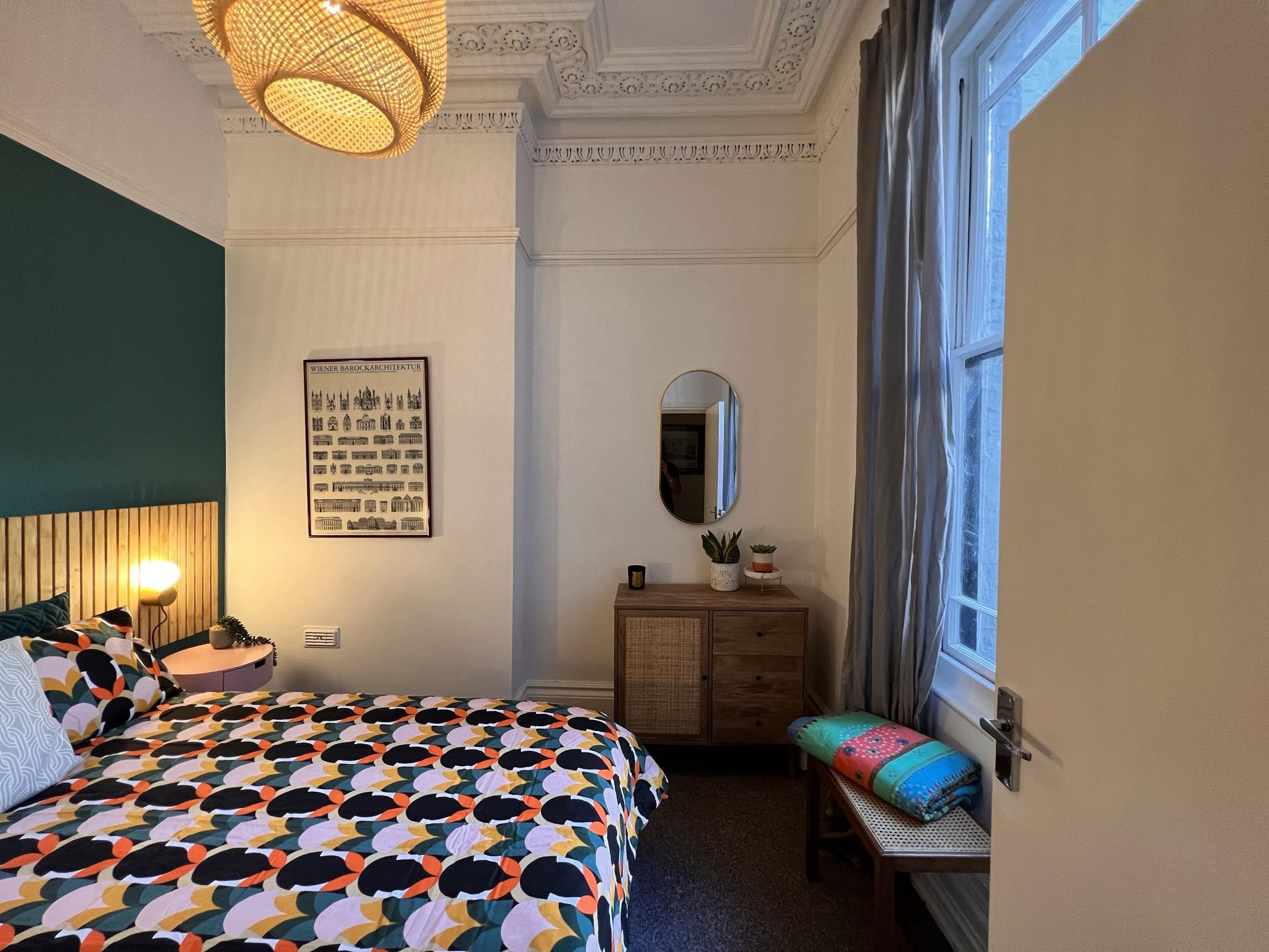 Blue bedroom with rattan pendant and ornate cornicing